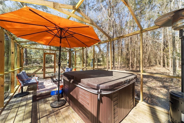 deck with a view of trees, a lanai, and a hot tub