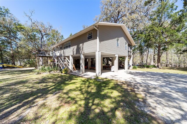 view of home's exterior with stairway, a lawn, and driveway