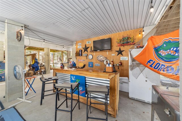 interior space with wood walls and concrete flooring