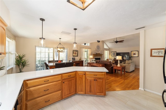 kitchen with light countertops, plenty of natural light, a fireplace, and vaulted ceiling