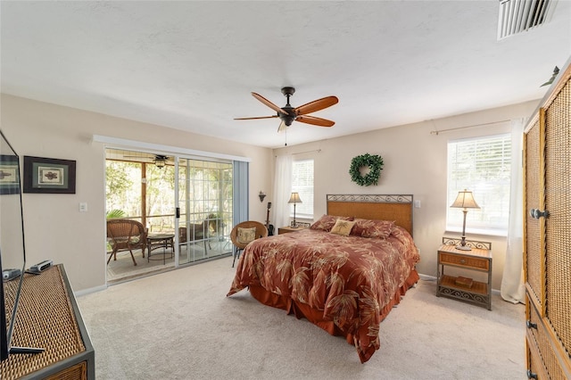 carpeted bedroom featuring visible vents, baseboards, a ceiling fan, and access to outside