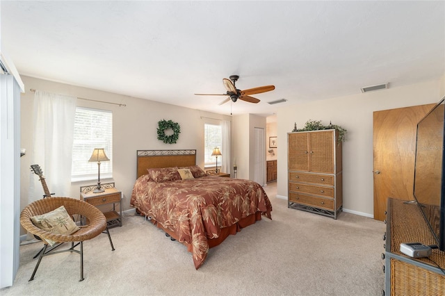 bedroom featuring light carpet, visible vents, multiple windows, and baseboards