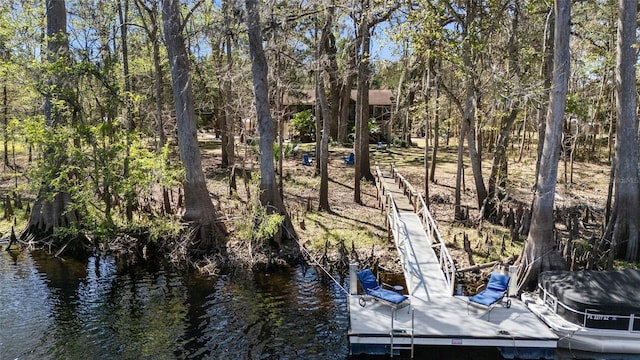 view of dock with a forest view and a water view