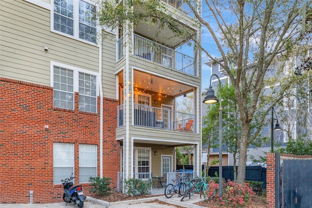 back of property featuring a patio, brick siding, and fence