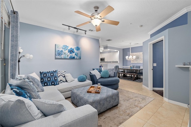 tiled living room featuring visible vents, ornamental molding, track lighting, ceiling fan with notable chandelier, and baseboards