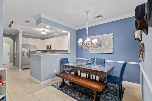 dining space featuring arched walkways, visible vents, an inviting chandelier, and ornamental molding