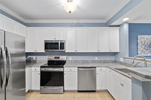 kitchen with ornamental molding, light tile patterned floors, appliances with stainless steel finishes, white cabinetry, and a sink