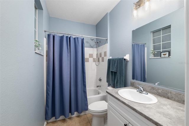 bathroom featuring tile patterned flooring, toilet, vanity, shower / bath combo with shower curtain, and a textured ceiling