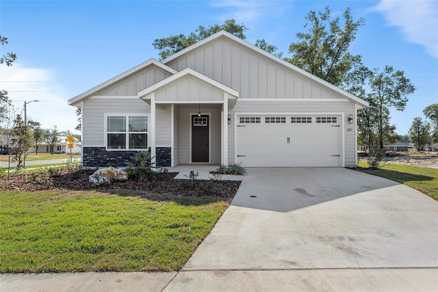 craftsman house featuring board and batten siding, a front lawn, concrete driveway, stone siding, and an attached garage