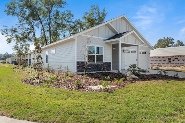 view of front of home with driveway, a front lawn, stone siding, board and batten siding, and an attached garage