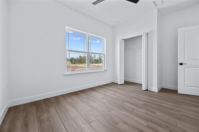 unfurnished bedroom featuring a closet, a ceiling fan, baseboards, and wood finished floors