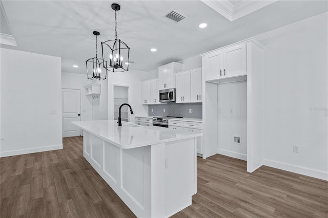 kitchen with visible vents, dark wood finished floors, a sink, appliances with stainless steel finishes, and backsplash