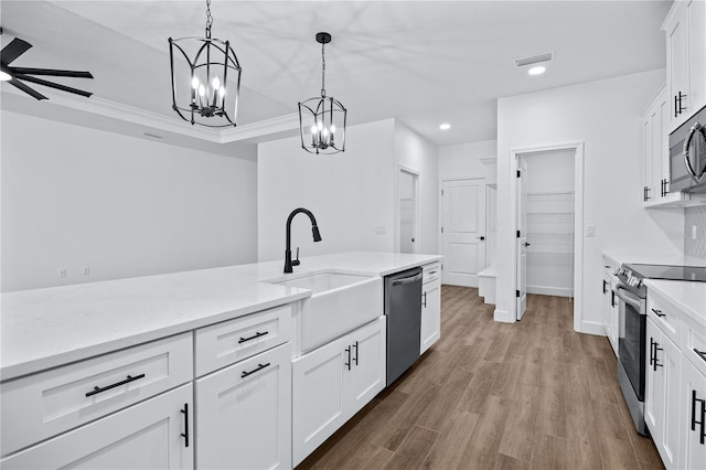 kitchen featuring visible vents, pendant lighting, appliances with stainless steel finishes, wood finished floors, and a sink