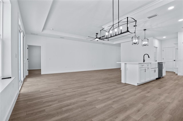 kitchen featuring light wood finished floors, open floor plan, a raised ceiling, and visible vents