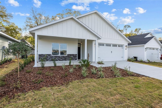 view of front of property featuring a front lawn, board and batten siding, concrete driveway, and a garage