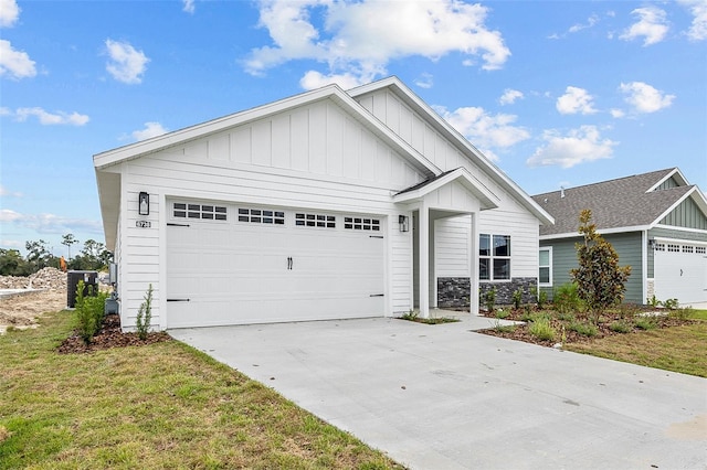 view of front facade with a garage, a front lawn, board and batten siding, and driveway