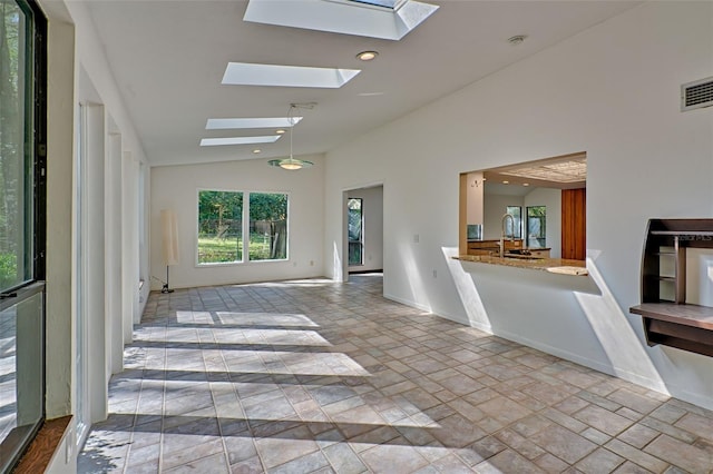 interior space featuring recessed lighting, stone finish flooring, baseboards, and a skylight