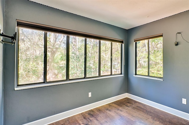 empty room featuring dark wood-style floors and baseboards