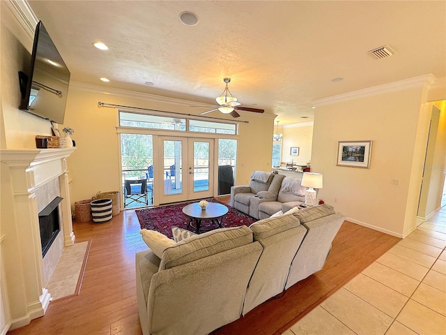 living room featuring visible vents, french doors, crown molding, and ceiling fan