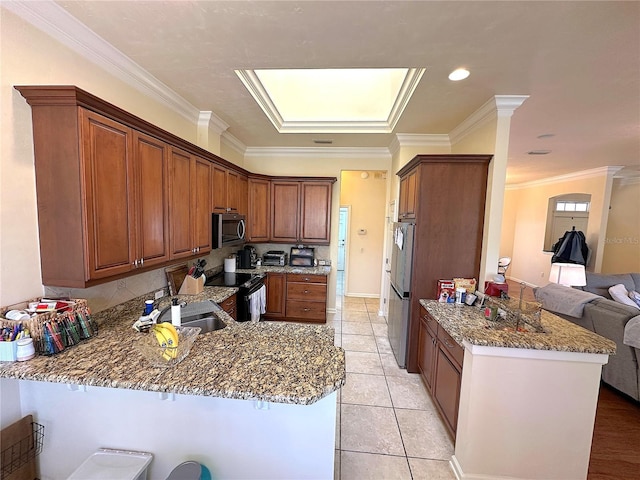 kitchen featuring appliances with stainless steel finishes, stone countertops, a peninsula, and a sink