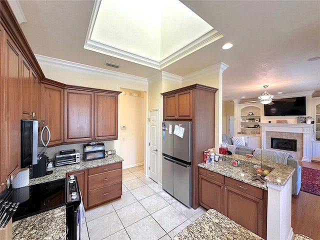 kitchen featuring visible vents, crown molding, open floor plan, appliances with stainless steel finishes, and a ceiling fan