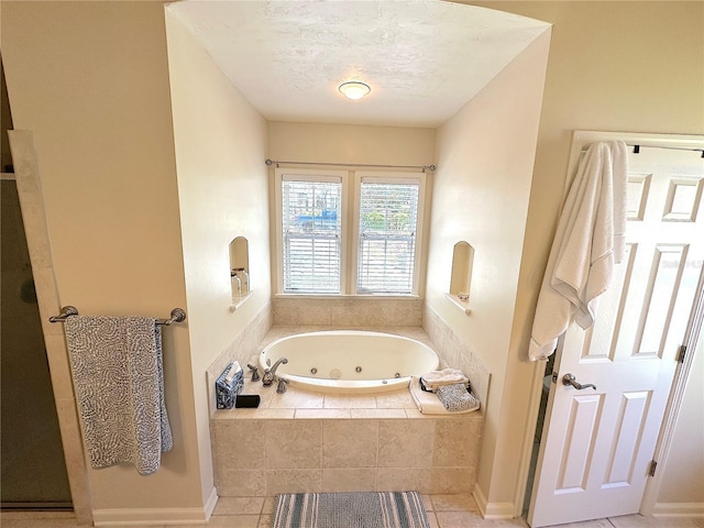 full bathroom featuring a textured ceiling, a tub with jets, tile patterned flooring, and a walk in shower