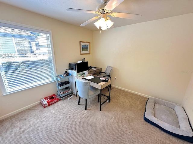 carpeted home office with a ceiling fan and baseboards