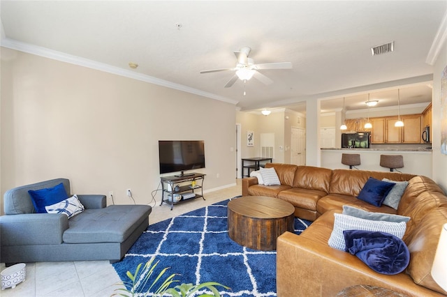 tiled living room with visible vents, baseboards, crown molding, and ceiling fan