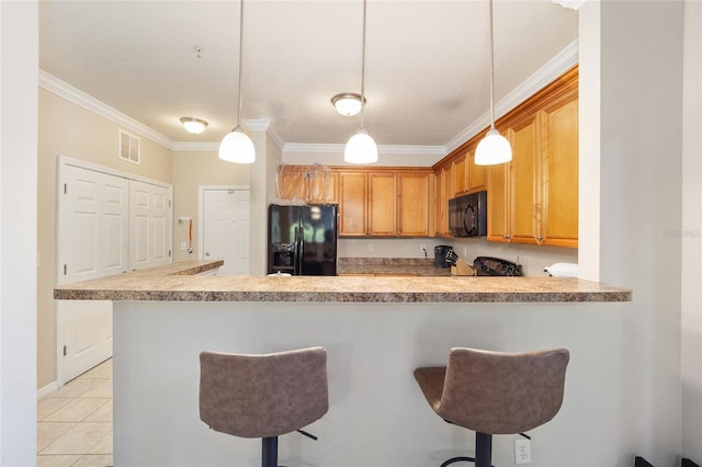 kitchen featuring a breakfast bar, black appliances, and crown molding