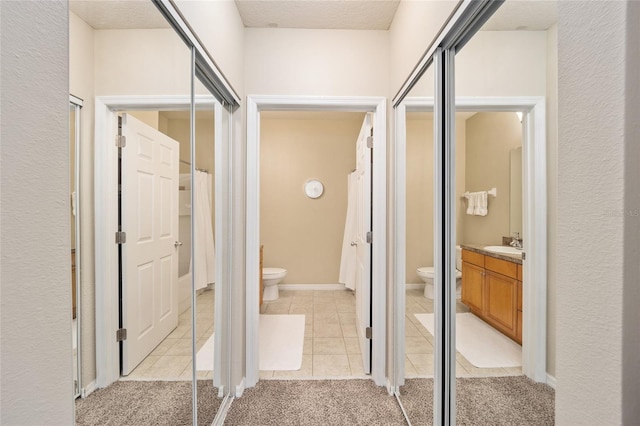 full bath featuring vanity, toilet, tile patterned flooring, and a textured ceiling