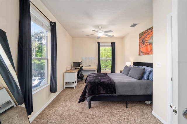 bedroom featuring visible vents, baseboards, light colored carpet, and a ceiling fan