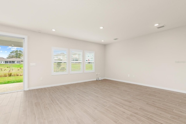 spare room featuring light wood-type flooring, visible vents, plenty of natural light, and recessed lighting