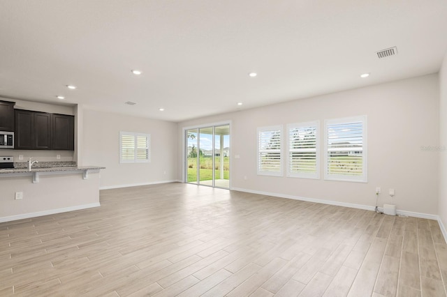 unfurnished living room with light wood-style flooring, recessed lighting, and visible vents