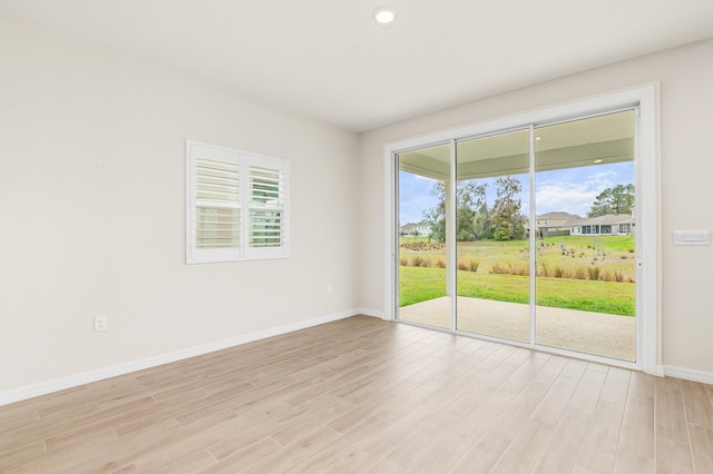 empty room featuring recessed lighting, baseboards, and light wood-style floors