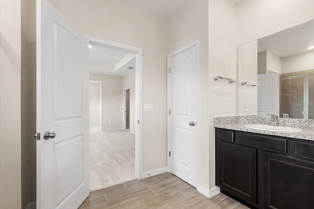 full bathroom featuring baseboards, a stall shower, vanity, and wood finish floors