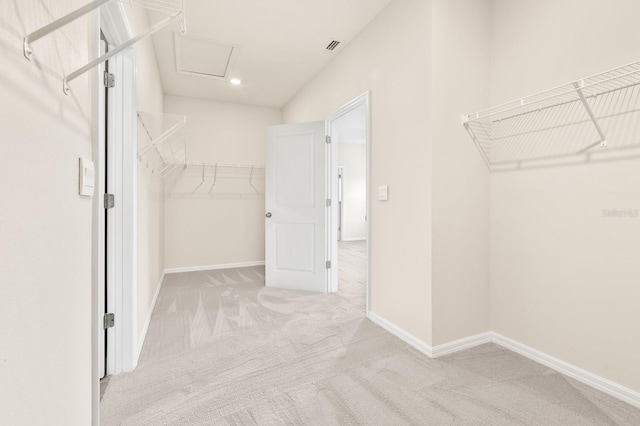 spacious closet with attic access, light colored carpet, and visible vents