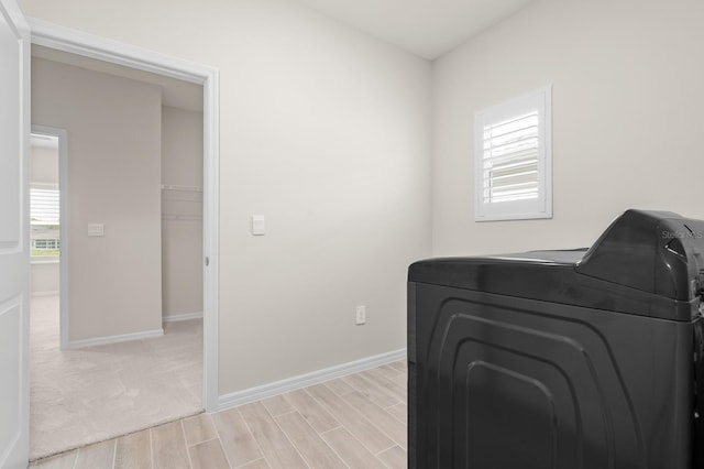 washroom featuring laundry area, washer / clothes dryer, baseboards, and wood finish floors