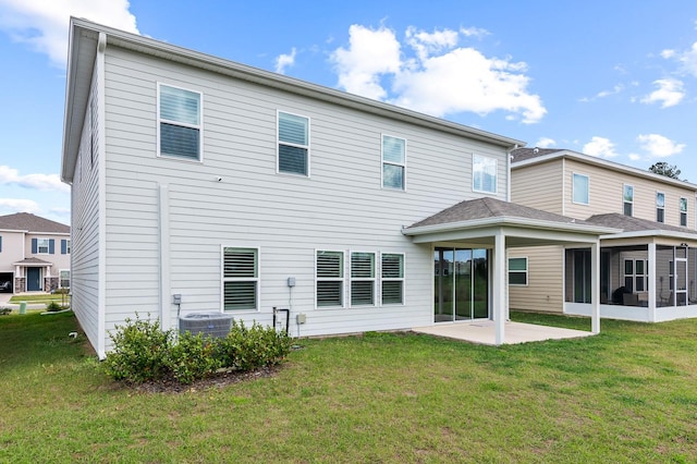 rear view of property with a patio area, a lawn, cooling unit, and a sunroom