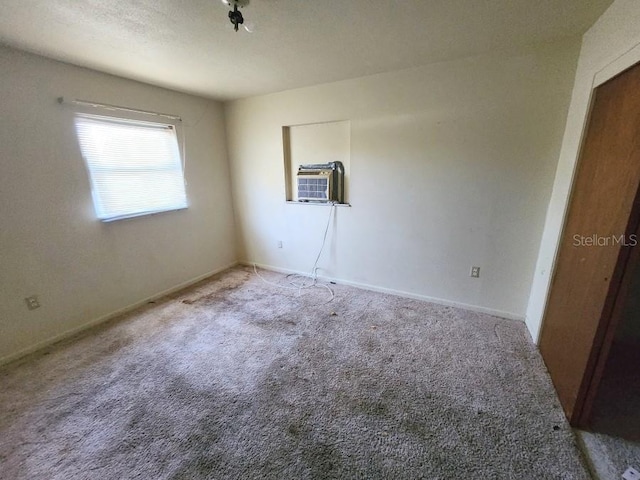 carpeted empty room with cooling unit and baseboards