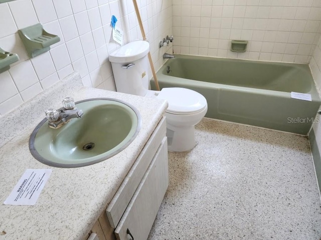 full bathroom with backsplash, toilet, vanity, tile walls, and speckled floor