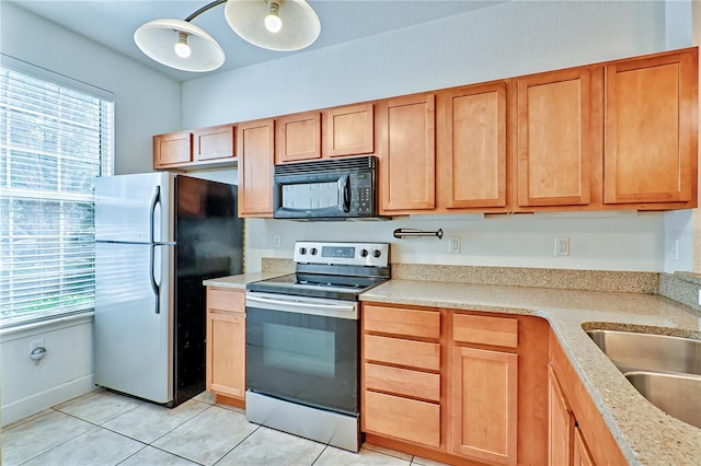 kitchen featuring light tile patterned floors, appliances with stainless steel finishes, and a sink