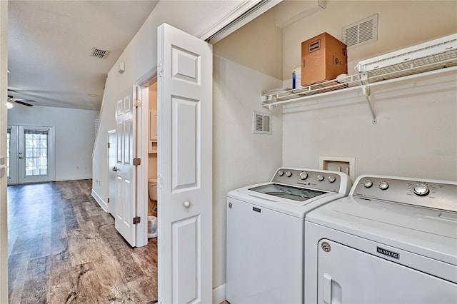 washroom featuring light wood-style floors, laundry area, washing machine and dryer, and visible vents