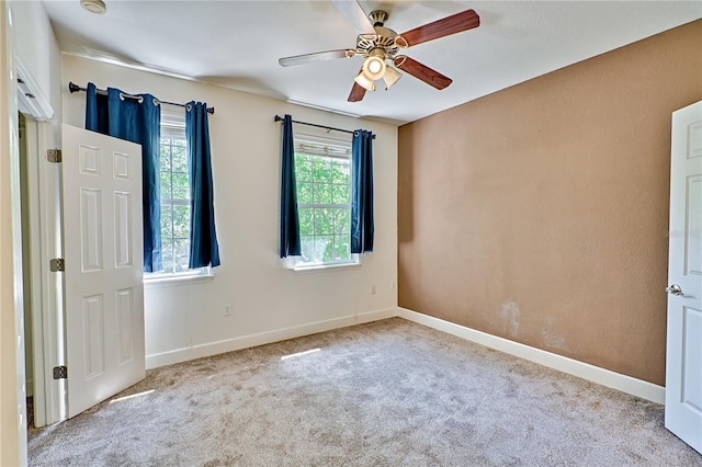 carpeted spare room with baseboards and ceiling fan