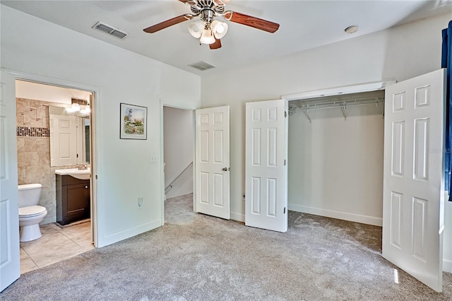 unfurnished bedroom with a closet, visible vents, light colored carpet, and a sink