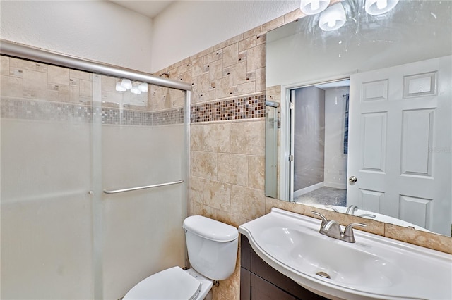 bathroom featuring a shower with door, toilet, tile walls, and vanity