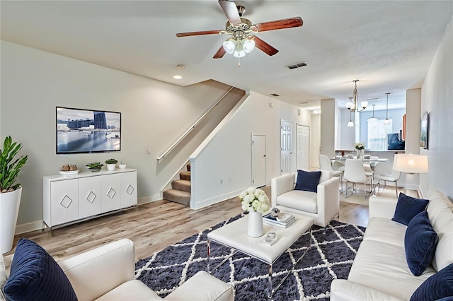 2508 SW 35th Pl Unit N83, Gainesville, FL 32608 - living room featuring stairs, wood finished floors, a chandelier, and a ceiling fan