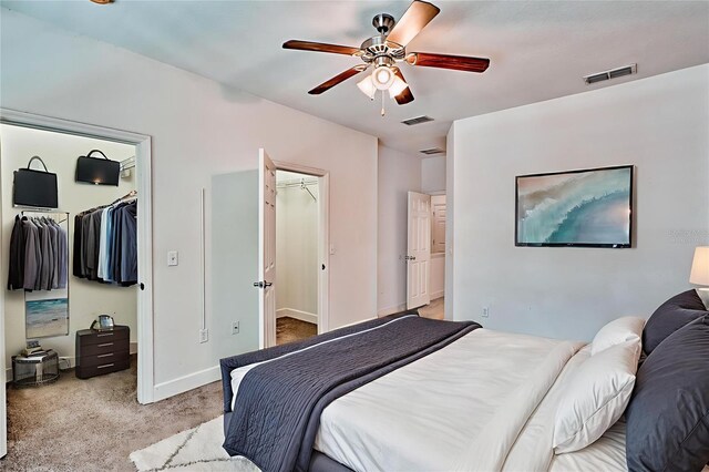2508 SW 35th Pl Unit N83, Gainesville, FL 32608 - bedroom with a walk in closet, light colored carpet, a closet, and ceiling fan