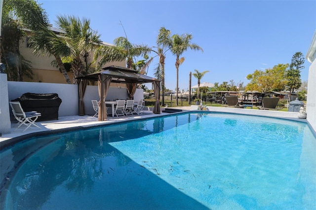 view of swimming pool featuring a gazebo, a patio area, a fenced in pool, and fence