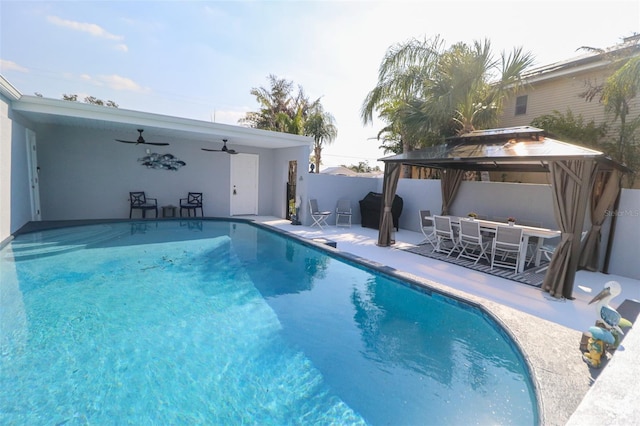 view of swimming pool featuring a patio, a fenced in pool, a ceiling fan, fence, and a gazebo