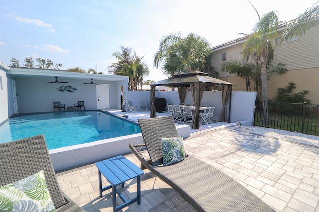 view of swimming pool with a ceiling fan, a patio, fence, a gazebo, and a fenced in pool